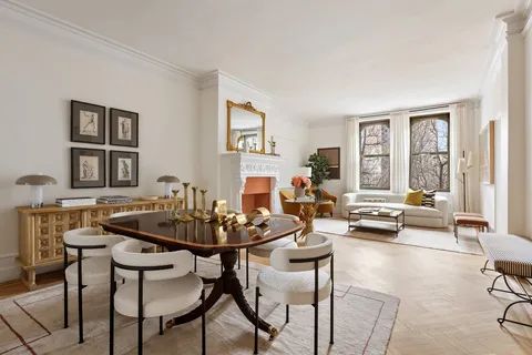 a living room with fireplace furniture and a large window