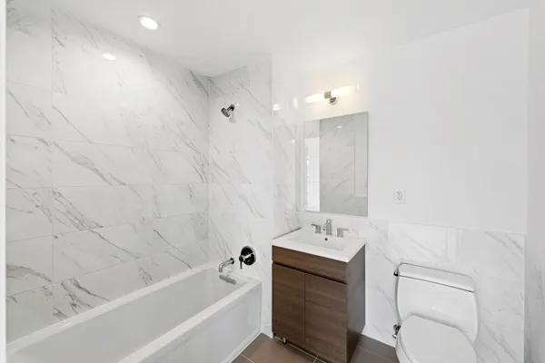 a bathroom with a tub sink double vanity and tub