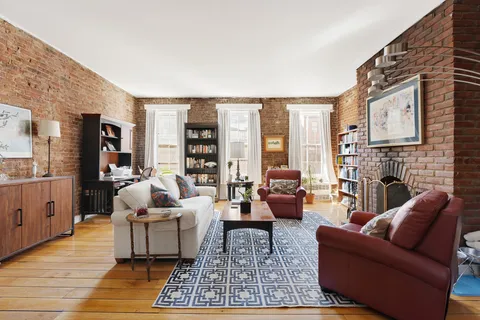 a living room with furniture large window and a fireplace