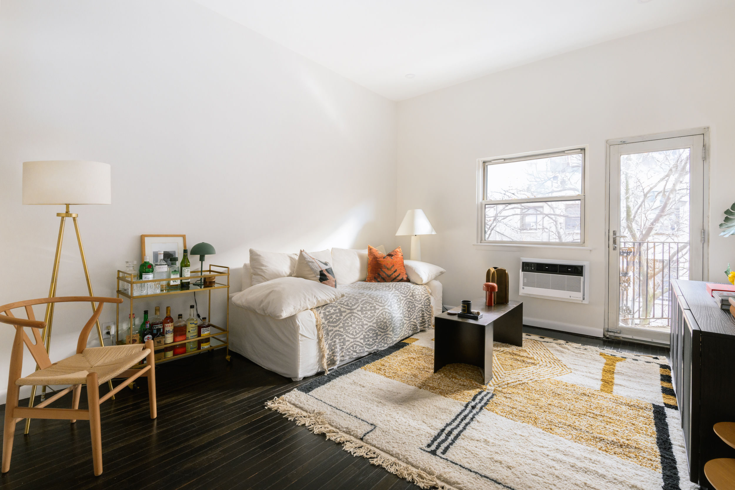 211 Thompson Street, Unit 4J Manhattan, NY 10012 - Photo 2 of 8 a bedroom with a bed and wooden floor