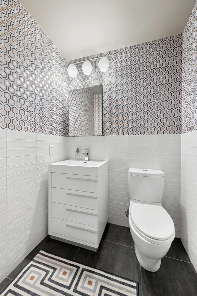 a bathroom with a sink a toilet a mirror and shower