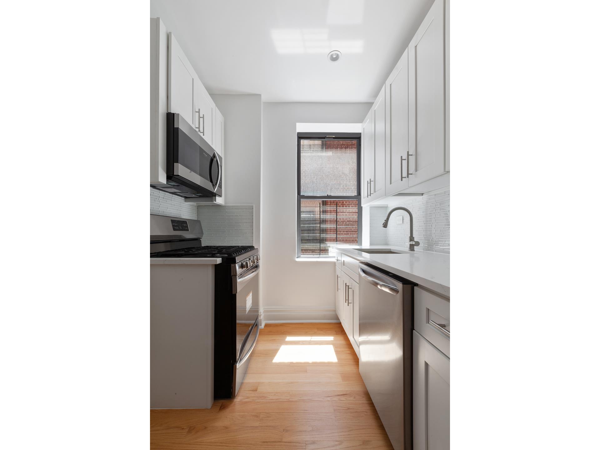 690 Riverside Drive, Unit 5D Manhattan, NY 10031 - Photo 5 of 9 a kitchen with stainless steel appliances granite countertop a sink and a stove