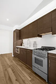 a kitchen with stainless steel appliances a stove a sink and white cabinets