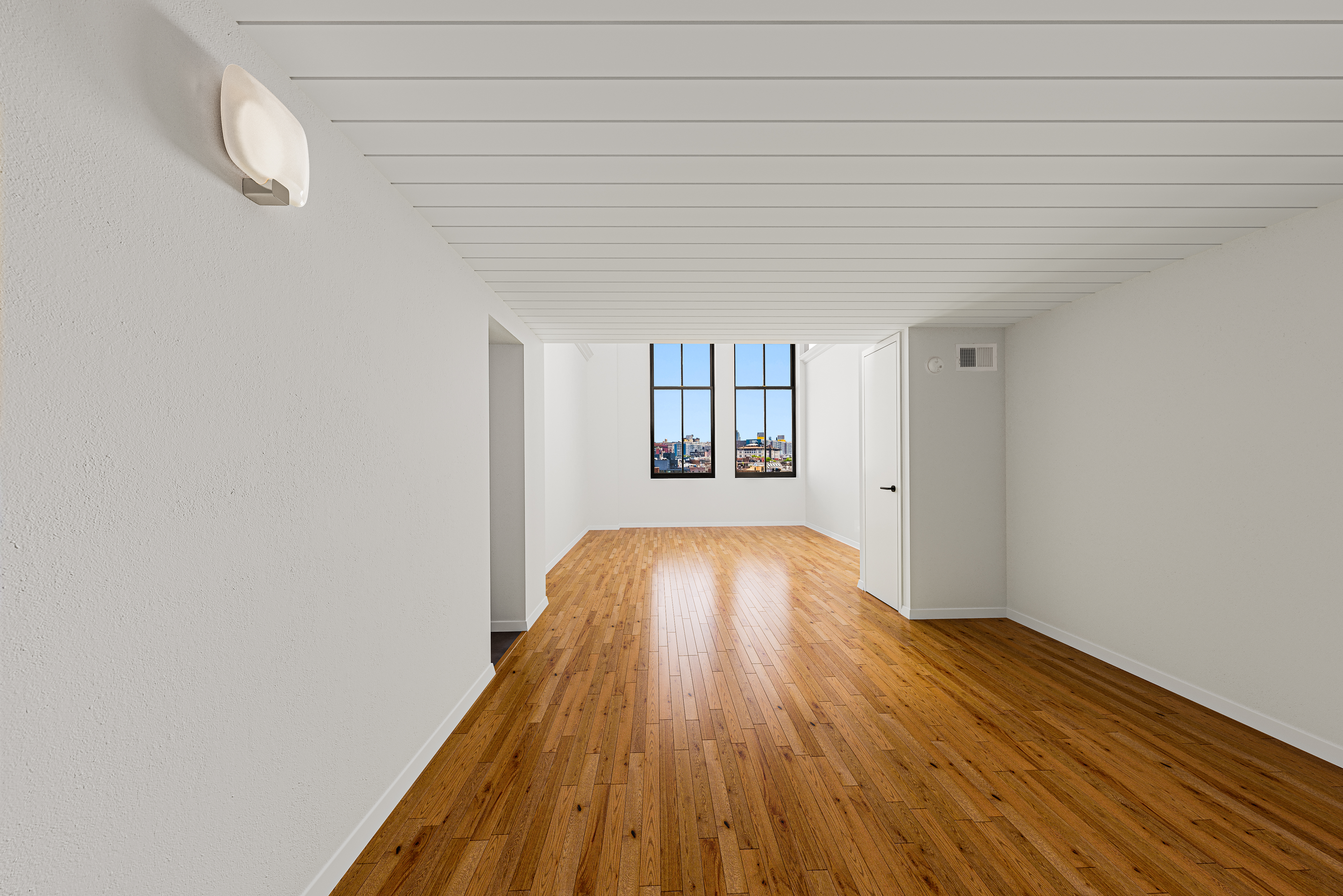 421 Hudson Street, Unit 504 Manhattan, NY 10014 - Photo 6 of 14 a view of empty room with wooden floor and fan
