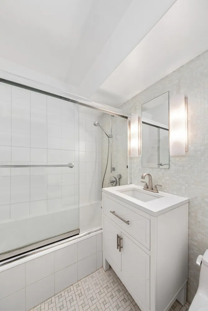 a bathroom with a sink a toilet and shower