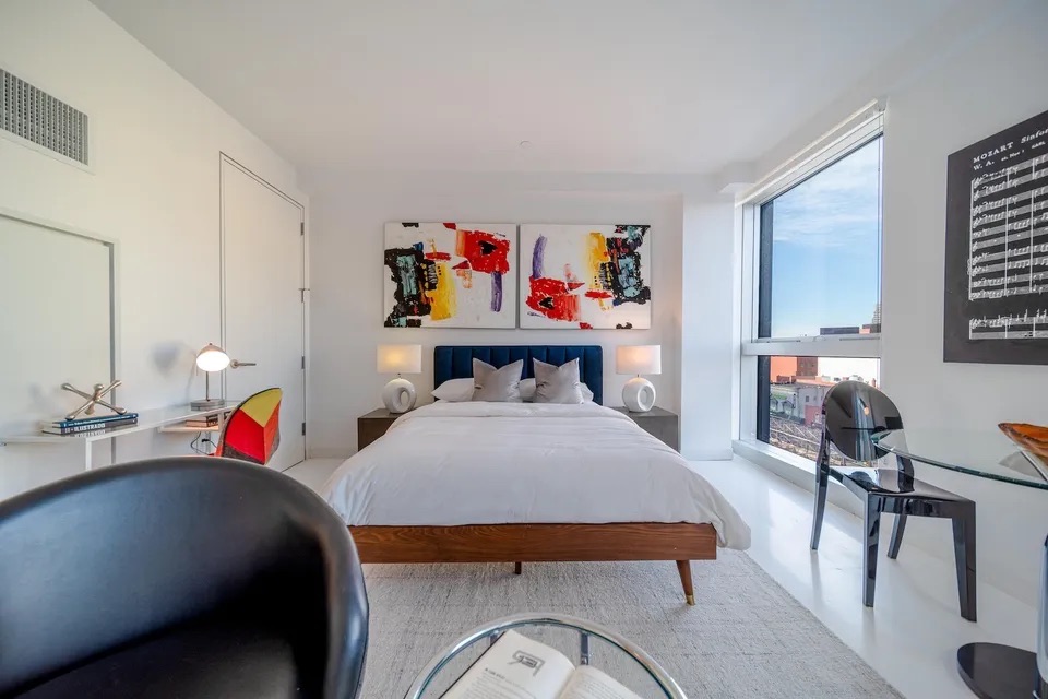 158 East 126th Street, Unit 730 Manhattan, NY 10035 - Photo 2 of 18 a bed room with a bed a couch and a painting on the wall