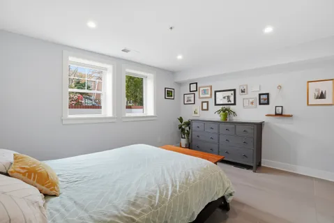 a bedroom with a bed and painting on the wall
