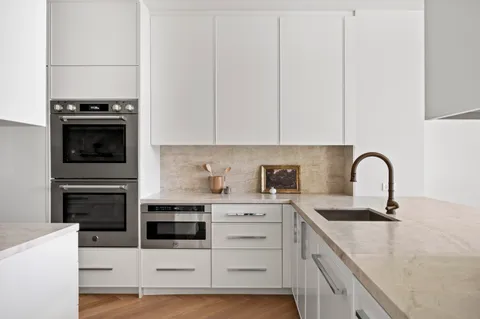 a kitchen with stainless steel appliances kitchen island a white stove top oven and sink
