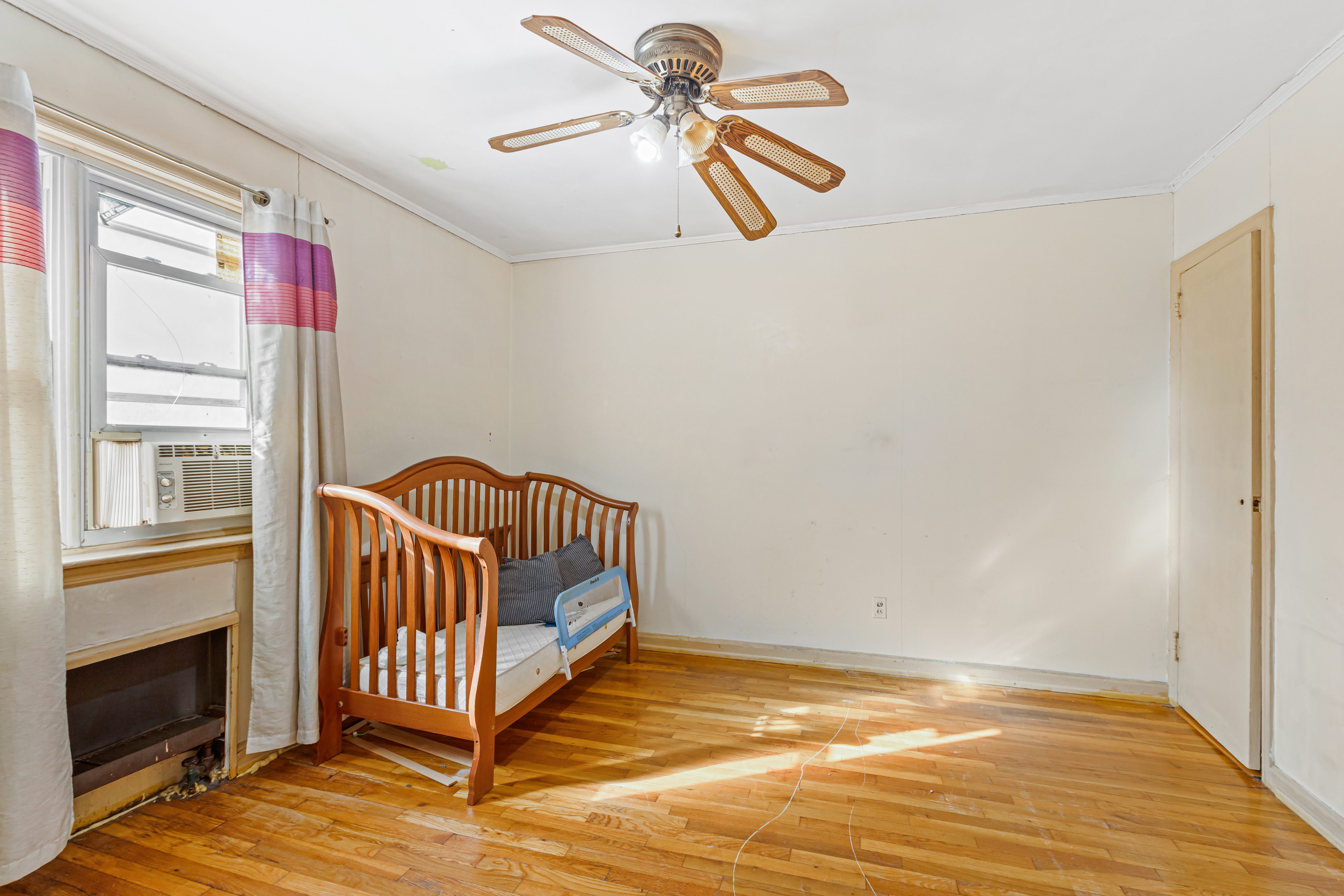 4802 6th Avenue Brooklyn, NY 11220 - Photo 14 of 21 a view of a livingroom with wooden floor and a ceiling fan