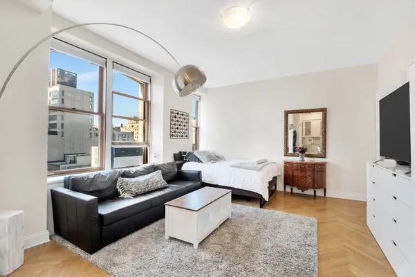 a bedroom with furniture and a large window
