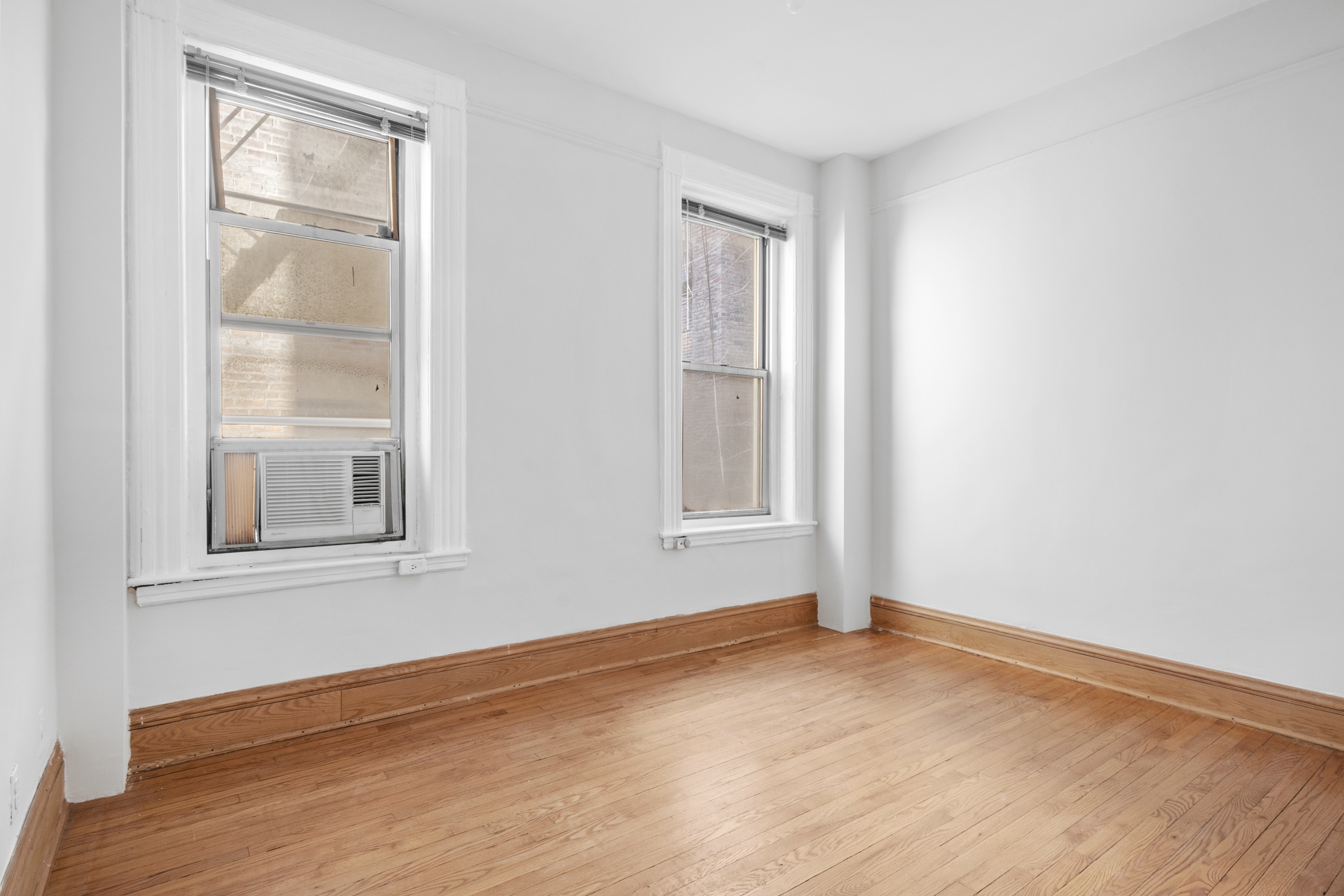 306 West 4th Street, Unit B1B2 Manhattan, NY 10014 - Photo 8 of 9 an empty room with wooden floor and windows