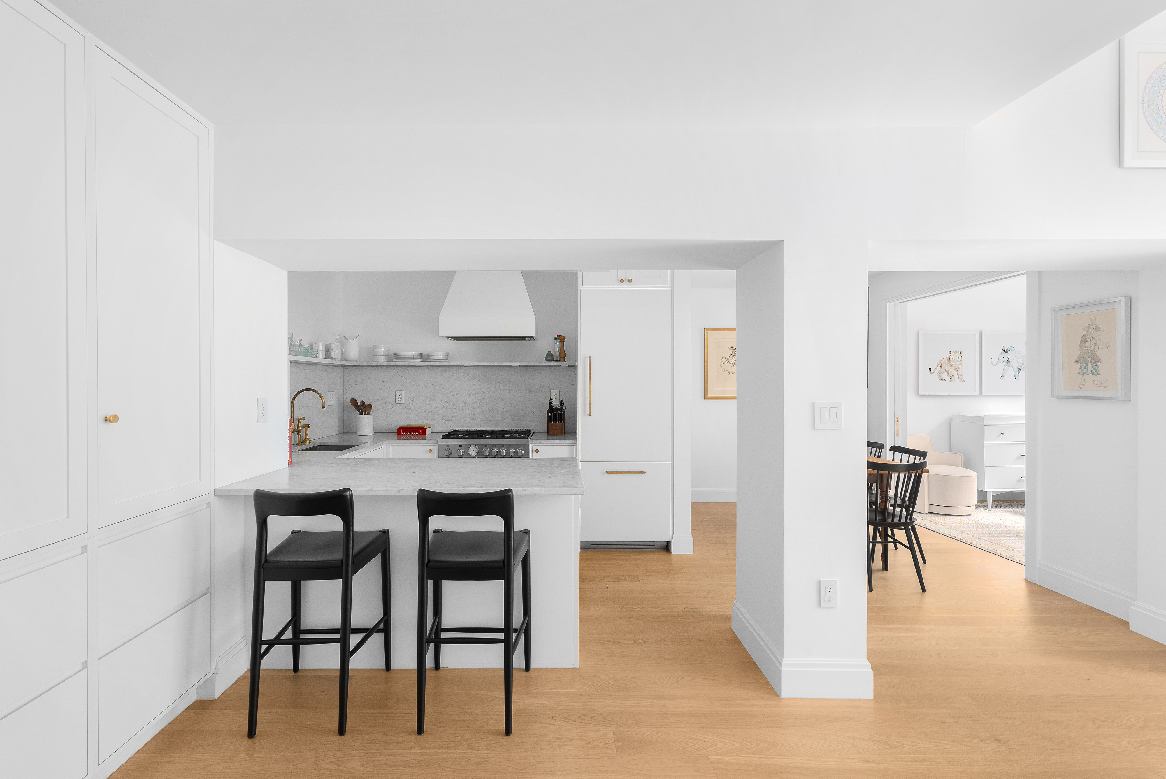 77 Bleecker Street, Unit 123E Manhattan, NY 10012 - Photo 3 of 13 a kitchen with stainless steel appliances a table and chairs in it