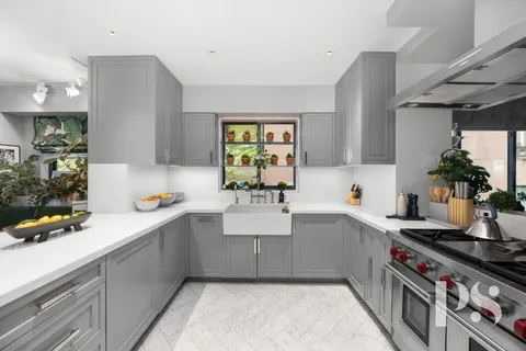 a kitchen with a sink a stove and cabinets