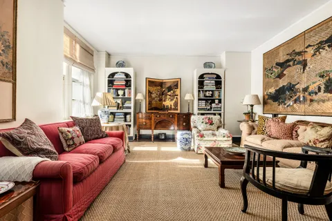 a living room with furniture a rug and a window