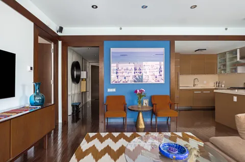 a living room with furniture and a dining table with kitchen view