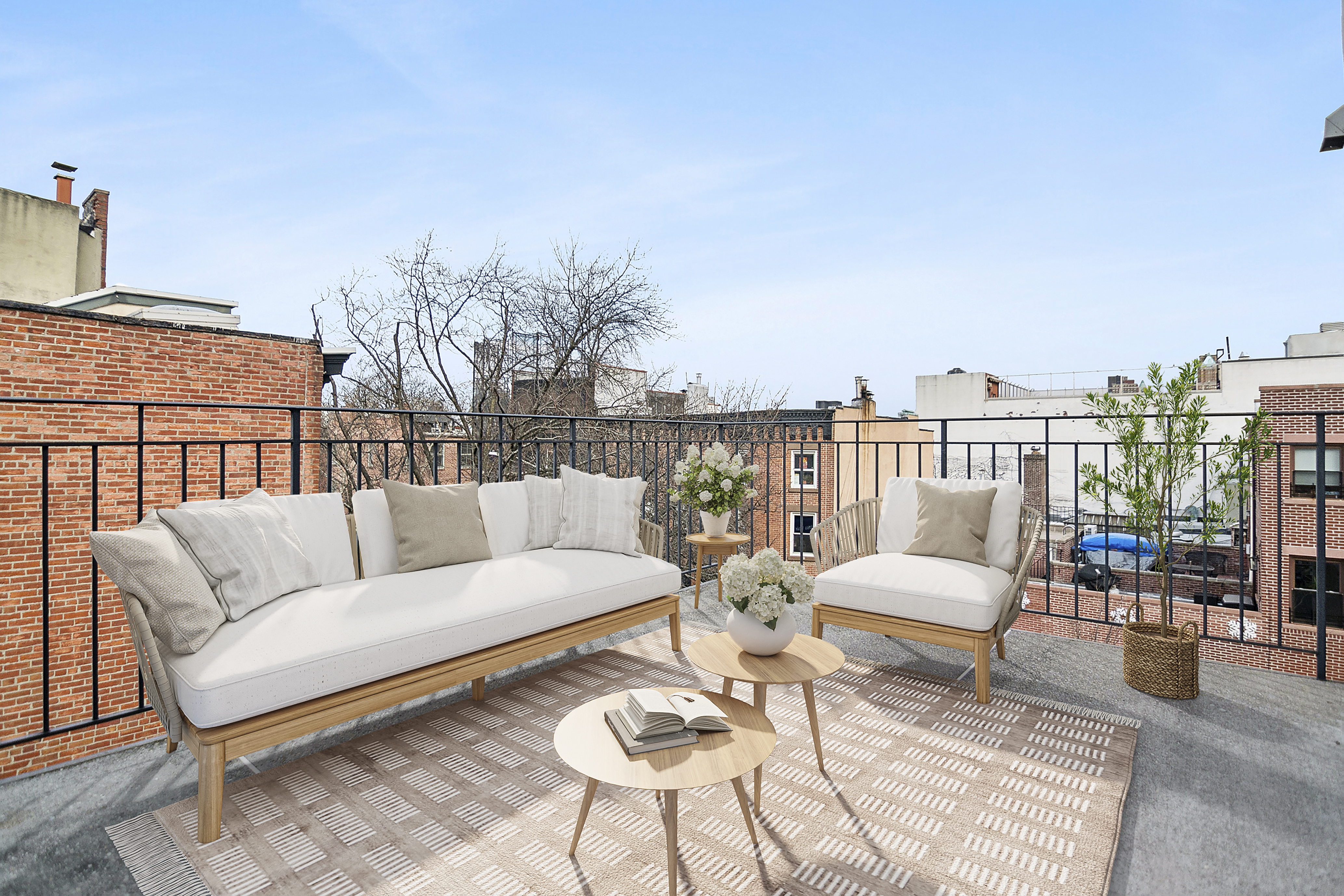 a roof deck with couches and potted plants with sky view