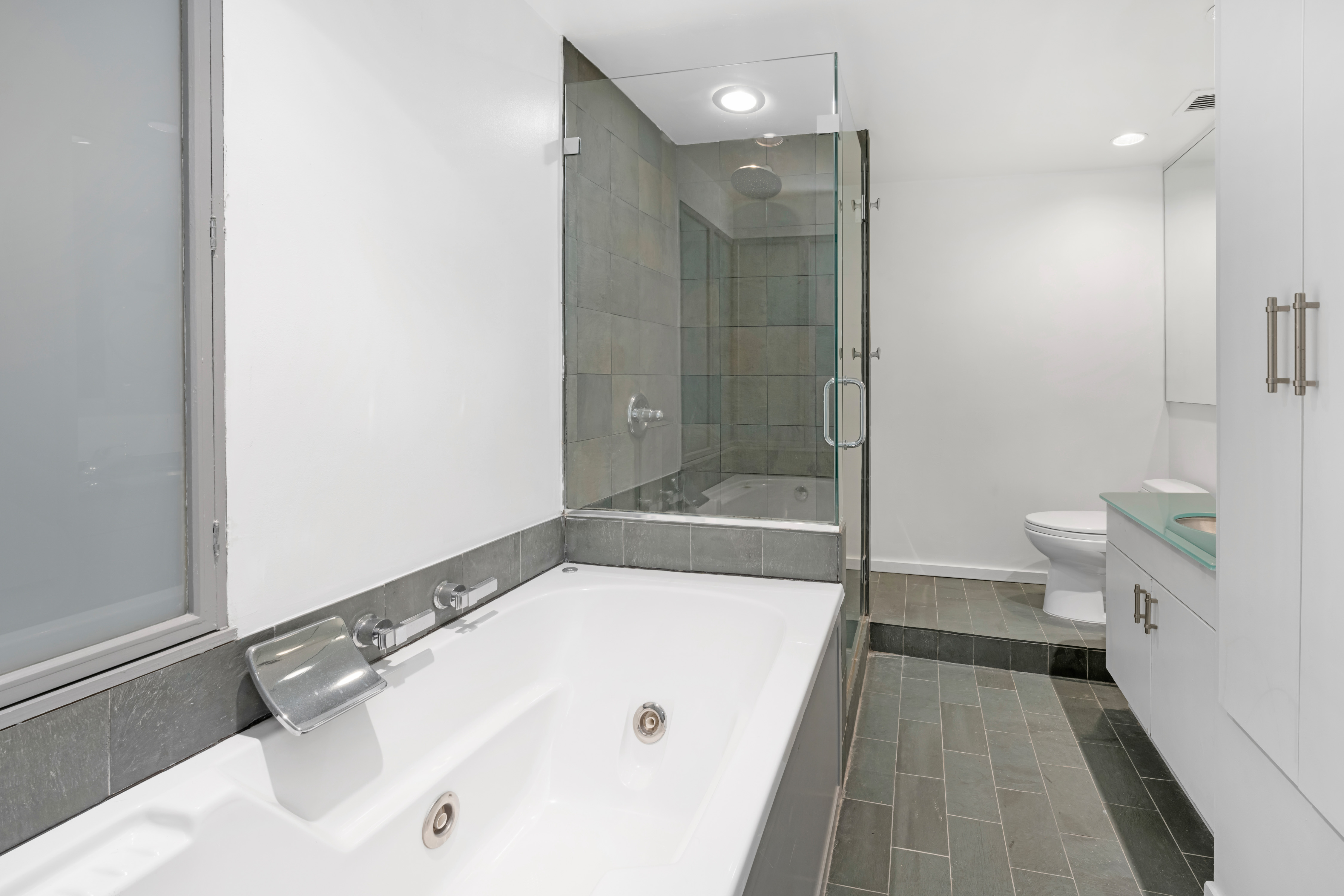 415 West 55th Street, Unit 4D Manhattan, NY 10019 - Photo 8 of 12 a bathroom with a tub a toilet and a shower