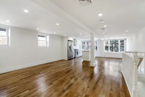 a view of empty room with wooden floor and windows