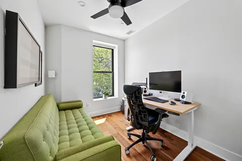 a view of a workspace with furniture and a window