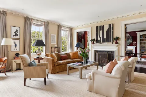 a living room with furniture fireplace and a large window