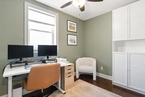 a view of a workspace with furniture and a window