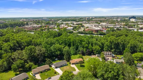 an aerial view of residential houses with outdoor space and trees