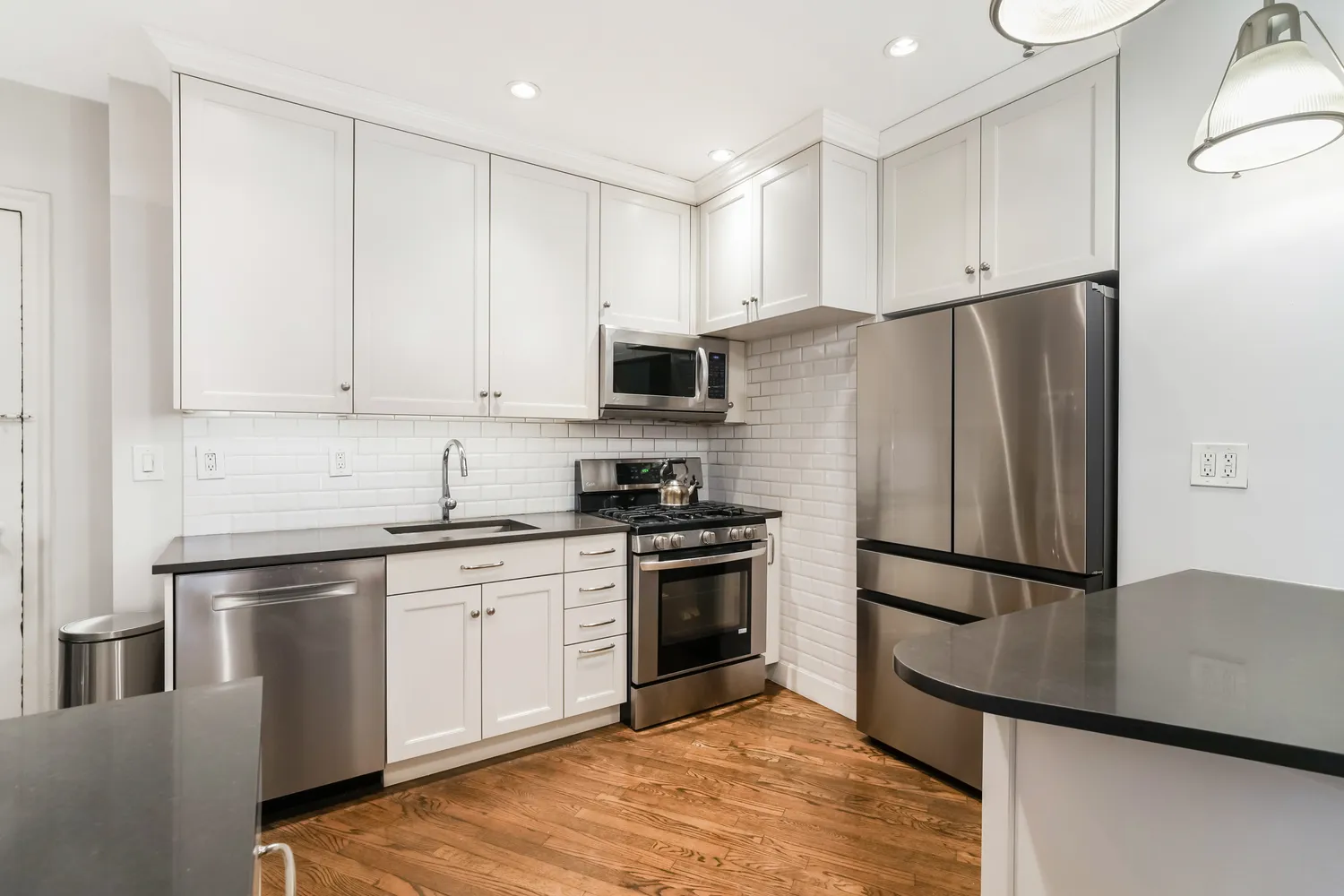 a kitchen with stainless steel appliances granite countertop a refrigerator sink and stove