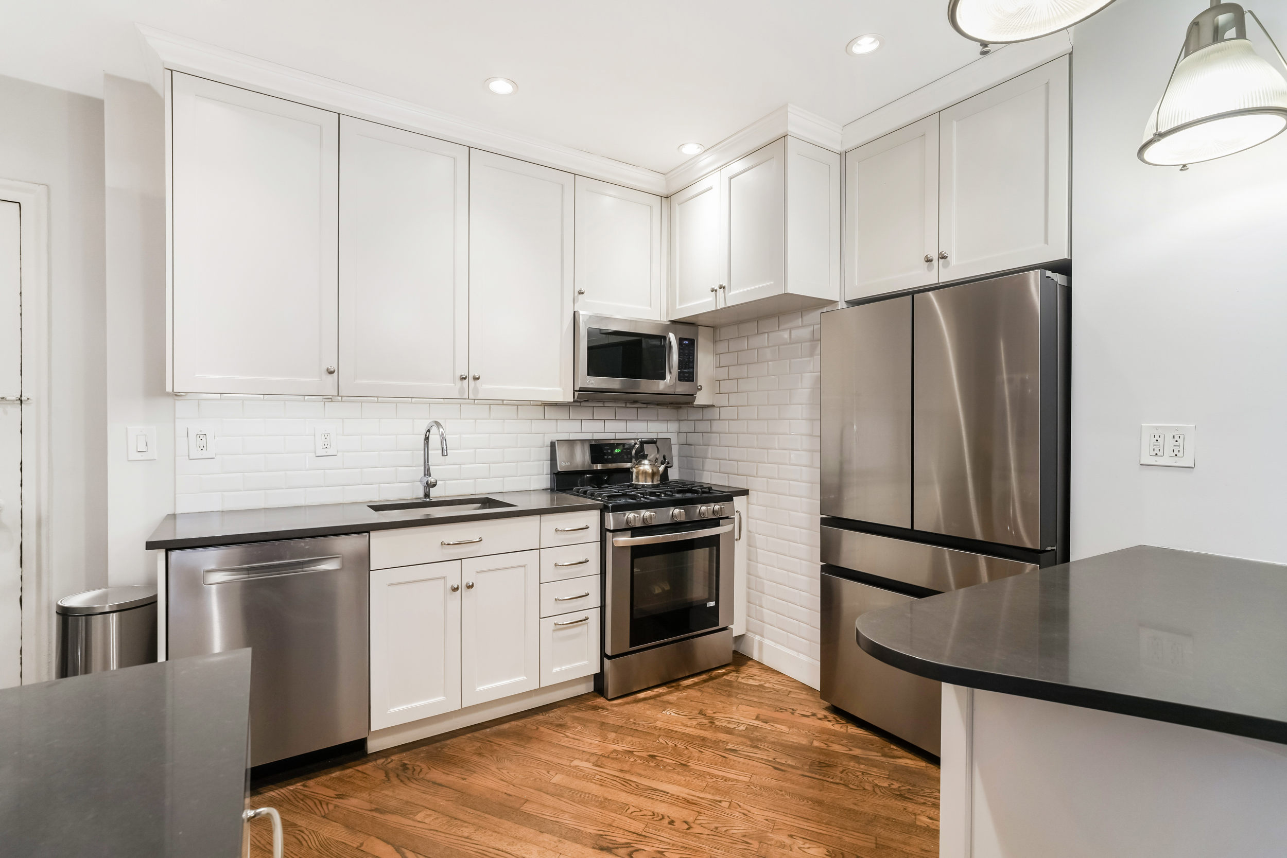 240 West 98th Street, Unit 3D Manhattan, NY 10025 - Photo 4 of 12 a kitchen with stainless steel appliances granite countertop a refrigerator sink and stove