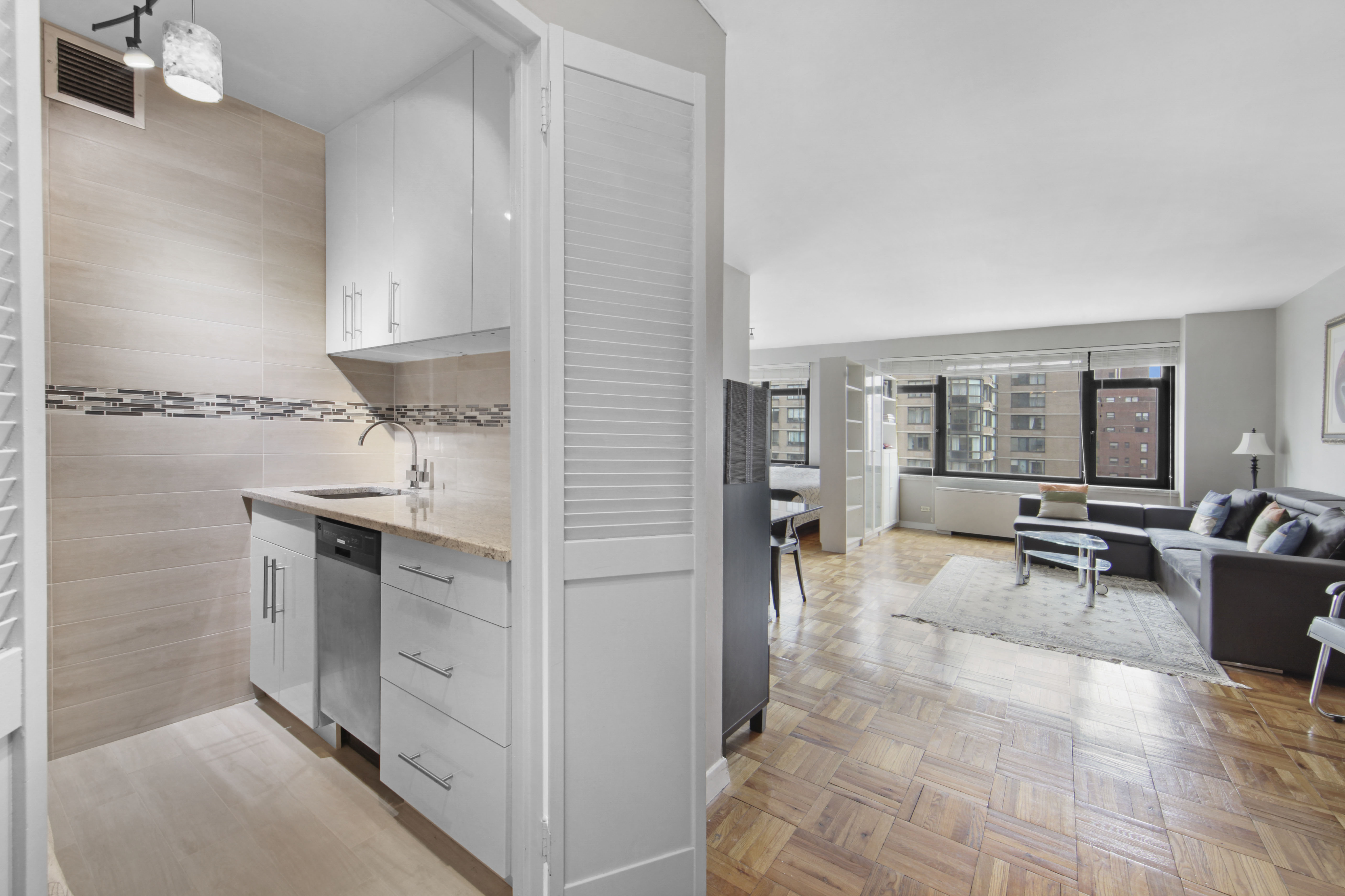 160 East 65th Street, Unit 8A Manhattan, NY 10065 - Photo 3 of 13 a living room with furniture a flat tv screen and large window