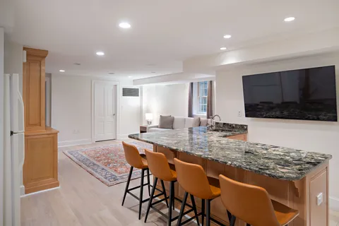 a kitchen with stainless steel appliances granite countertop a stove a sink a microwave a refrigerator and chairs
