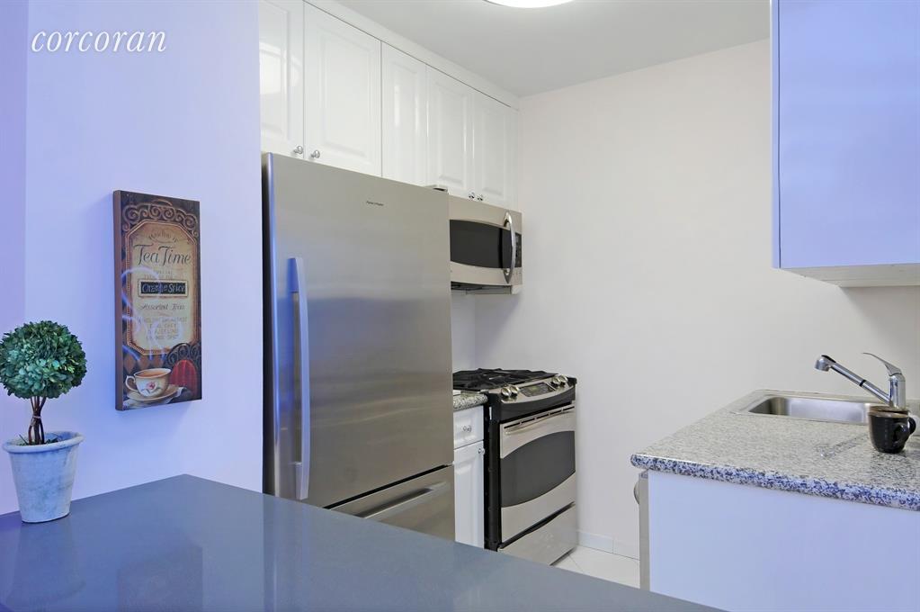 220 East 65th Street, Unit 3K Manhattan, NY 10065 - Photo 2 of 13 a kitchen with stainless steel appliances granite countertop a refrigerator and a sink