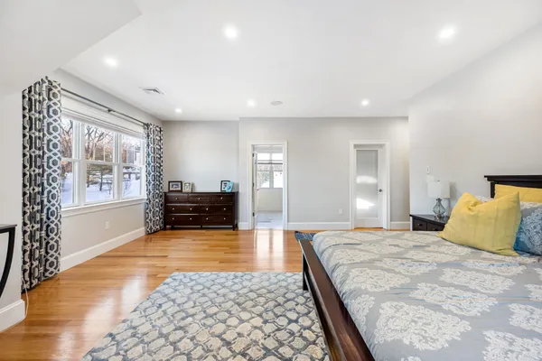 a large bedroom with a bed and wooden floor