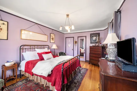 a spacious bedroom with a bed and a flat screen tv