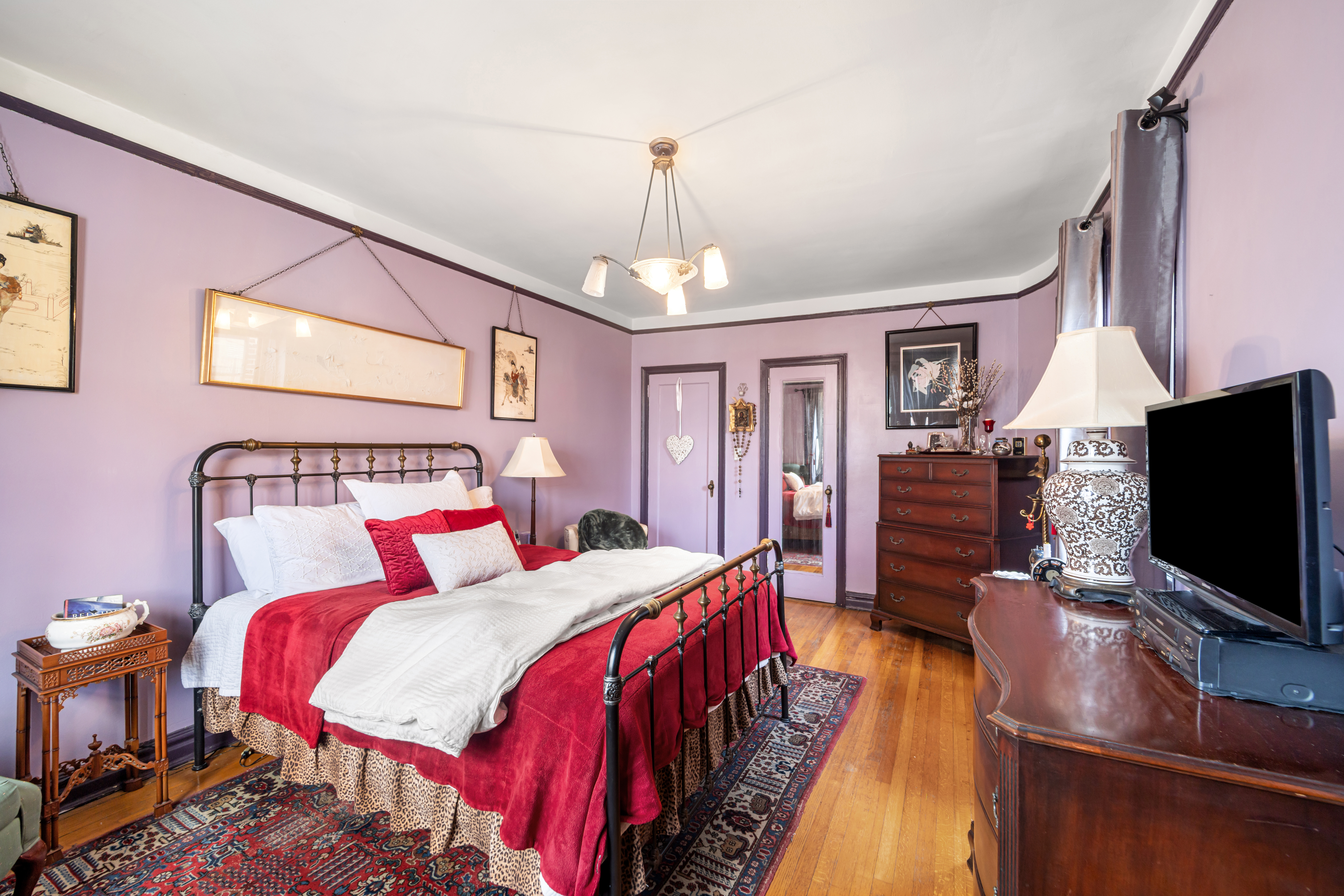 34-24 82nd Street, Unit 6N Queens, NY 11372 - Photo 10 of 15 a spacious bedroom with a bed and a flat screen tv