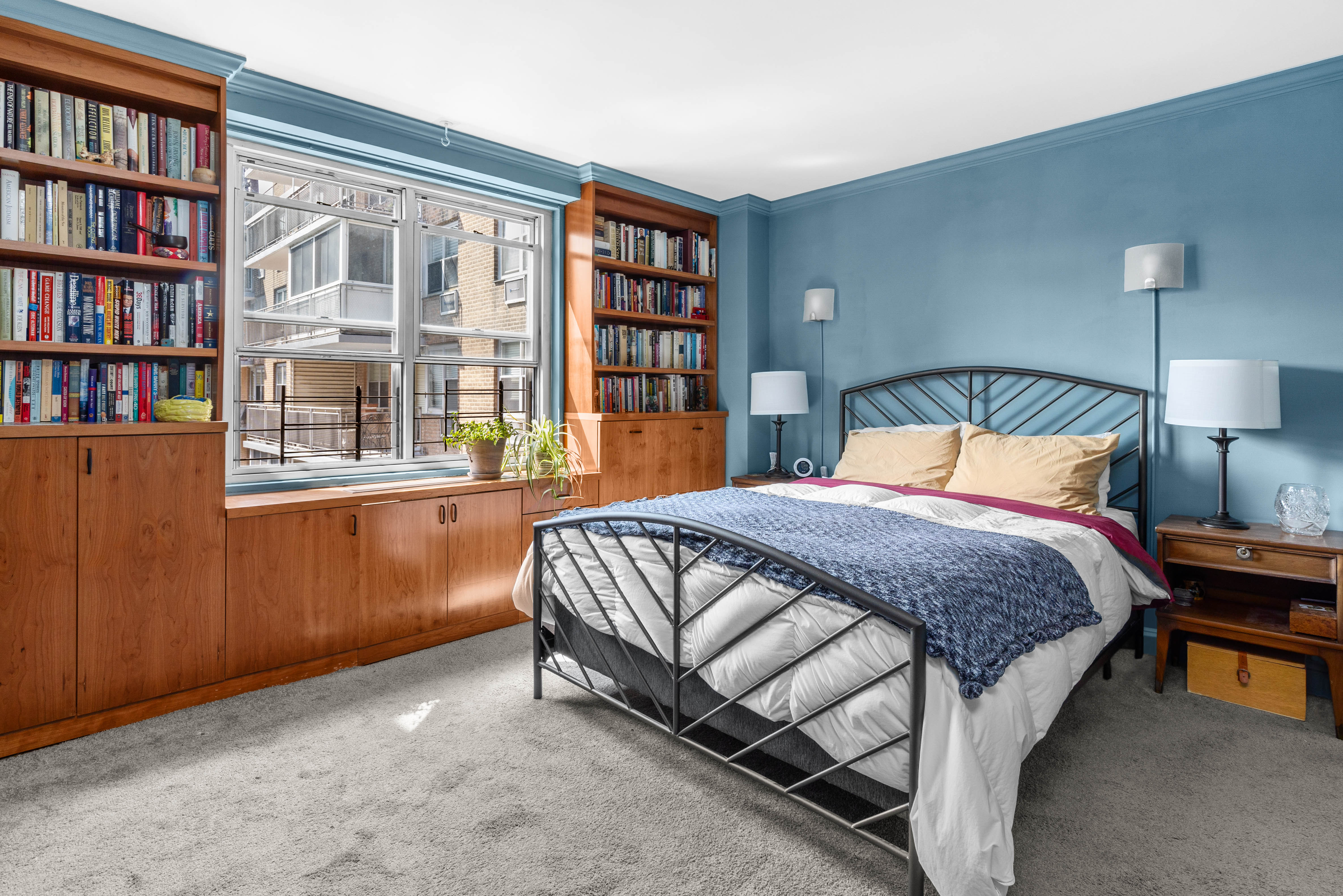 303 West 66th Street, Unit 18EE Manhattan, NY 10023 - Photo 12 of 24 a bedroom with a bed and a book shelf