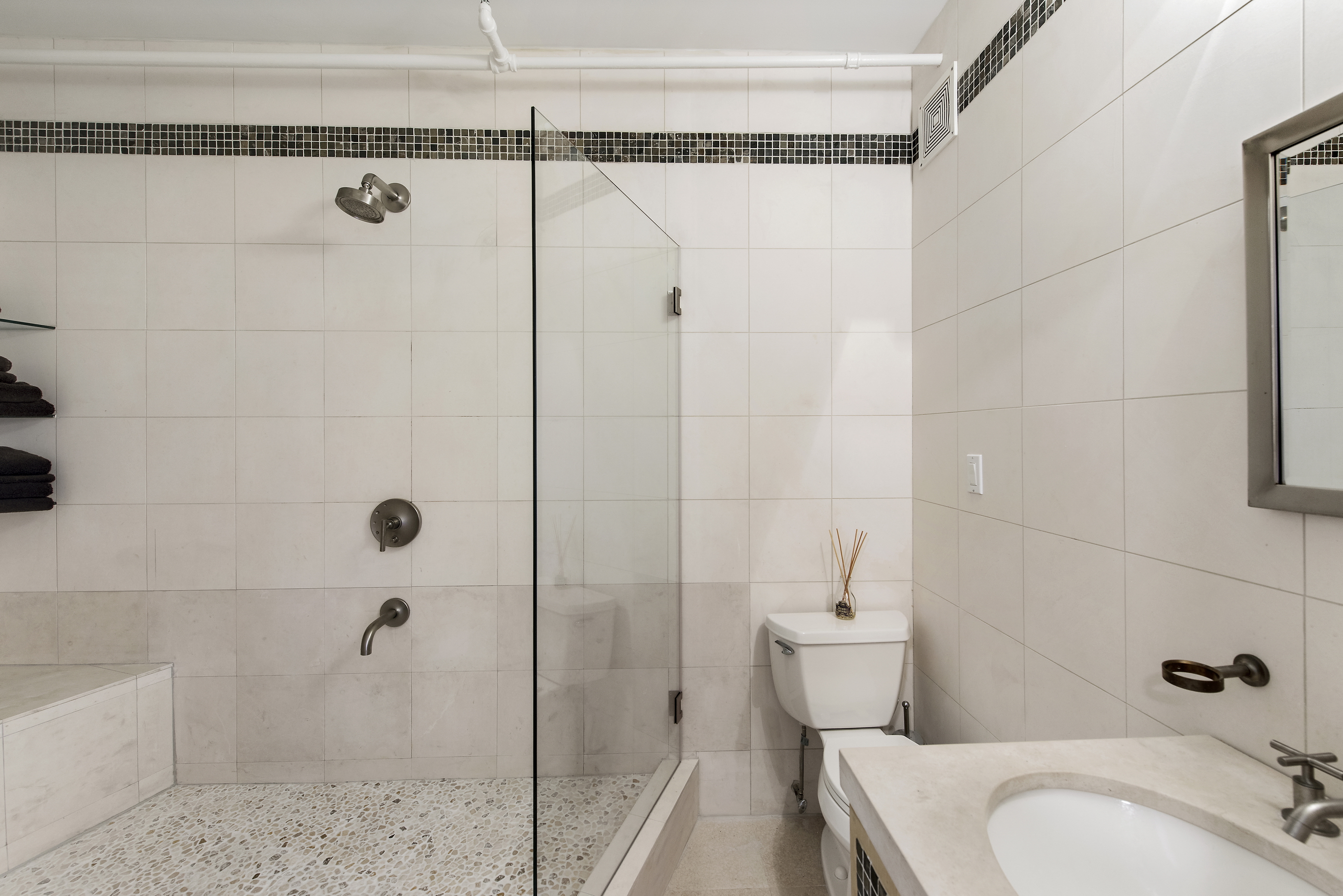 108 Wooster Street, Unit 5B Manhattan, NY 10012 - Photo 4 of 9 a bathroom with a granite countertop bathtub shower sink and toilet