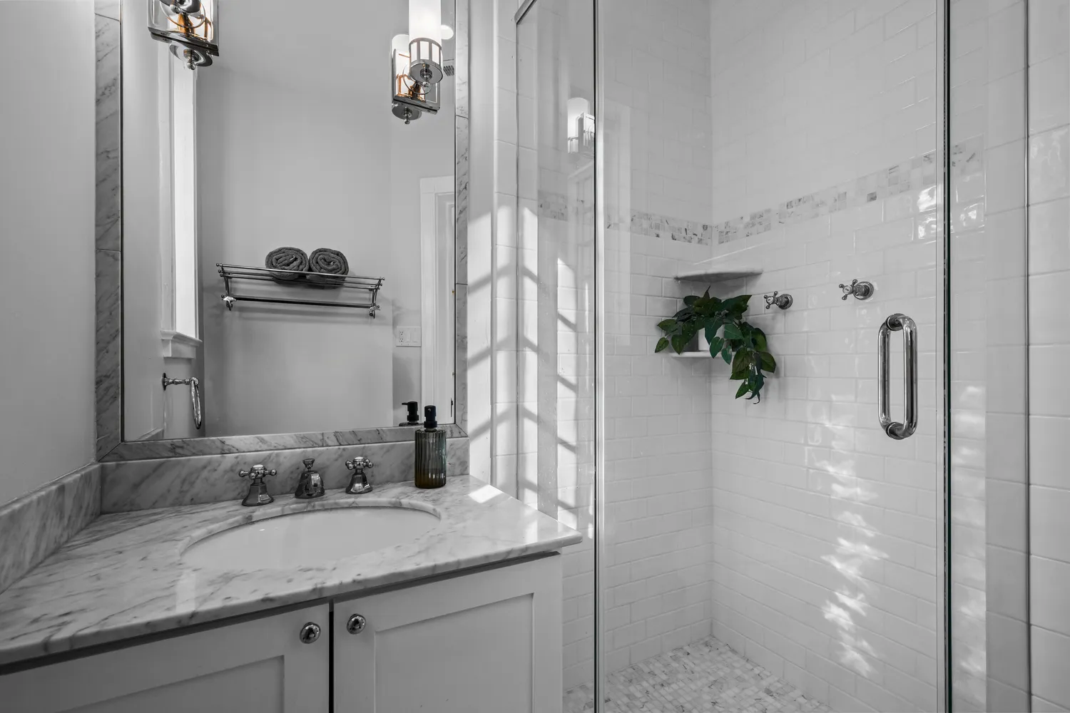 a bathroom with a granite countertop sink a mirror and shower