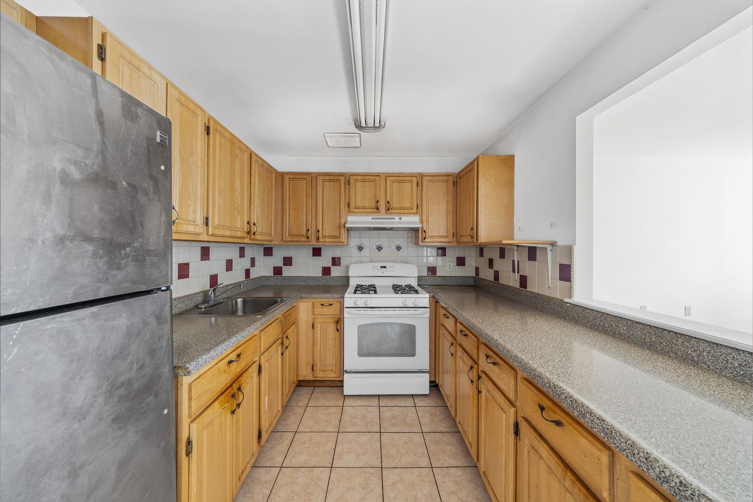 a kitchen with granite countertop a sink stainless steel appliances and cabinets
