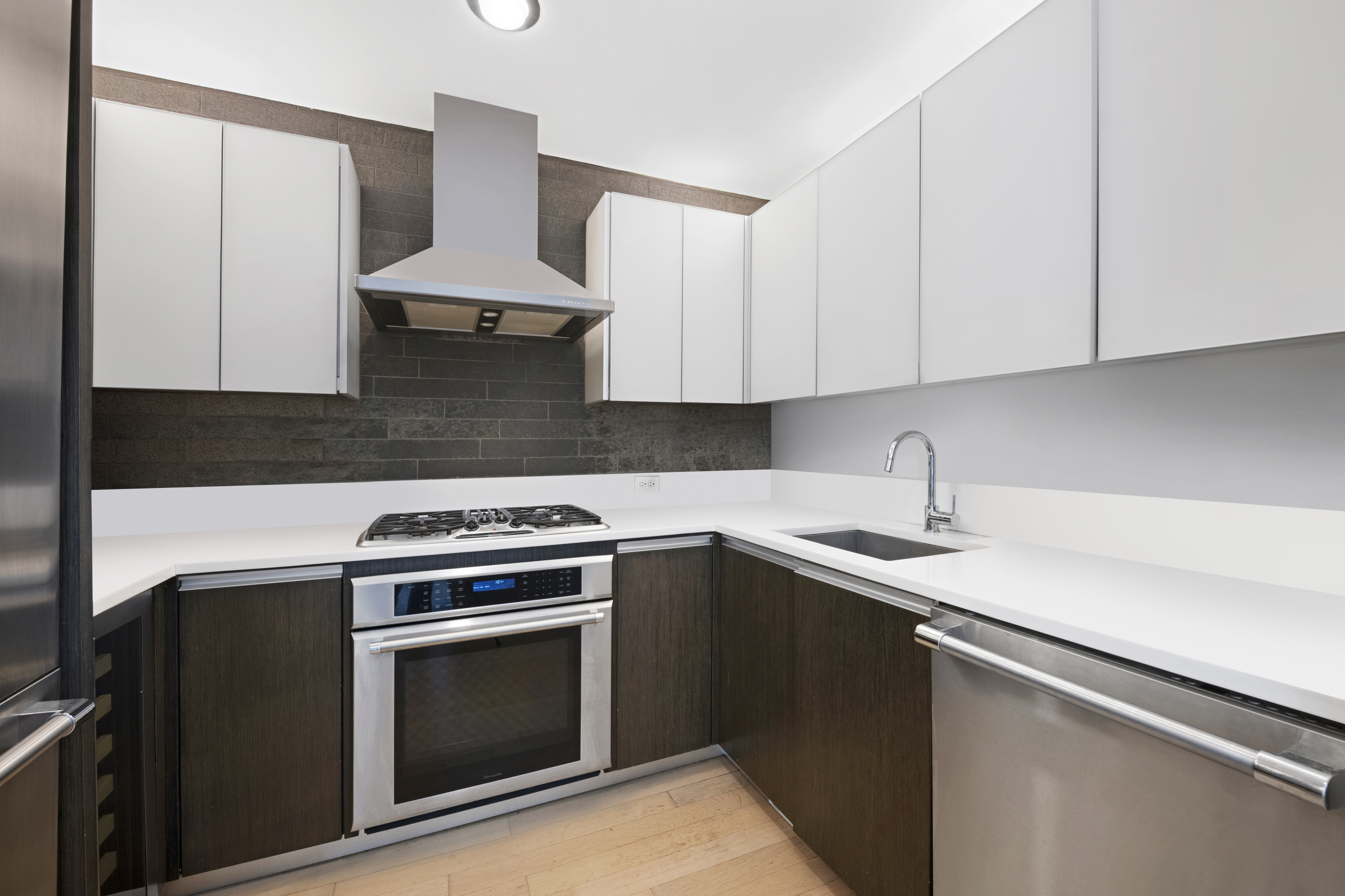 247 West 46th Street, Unit 2305 Manhattan, NY 10036 - Photo 5 of 13 a kitchen with granite countertop a stove sink and cabinets