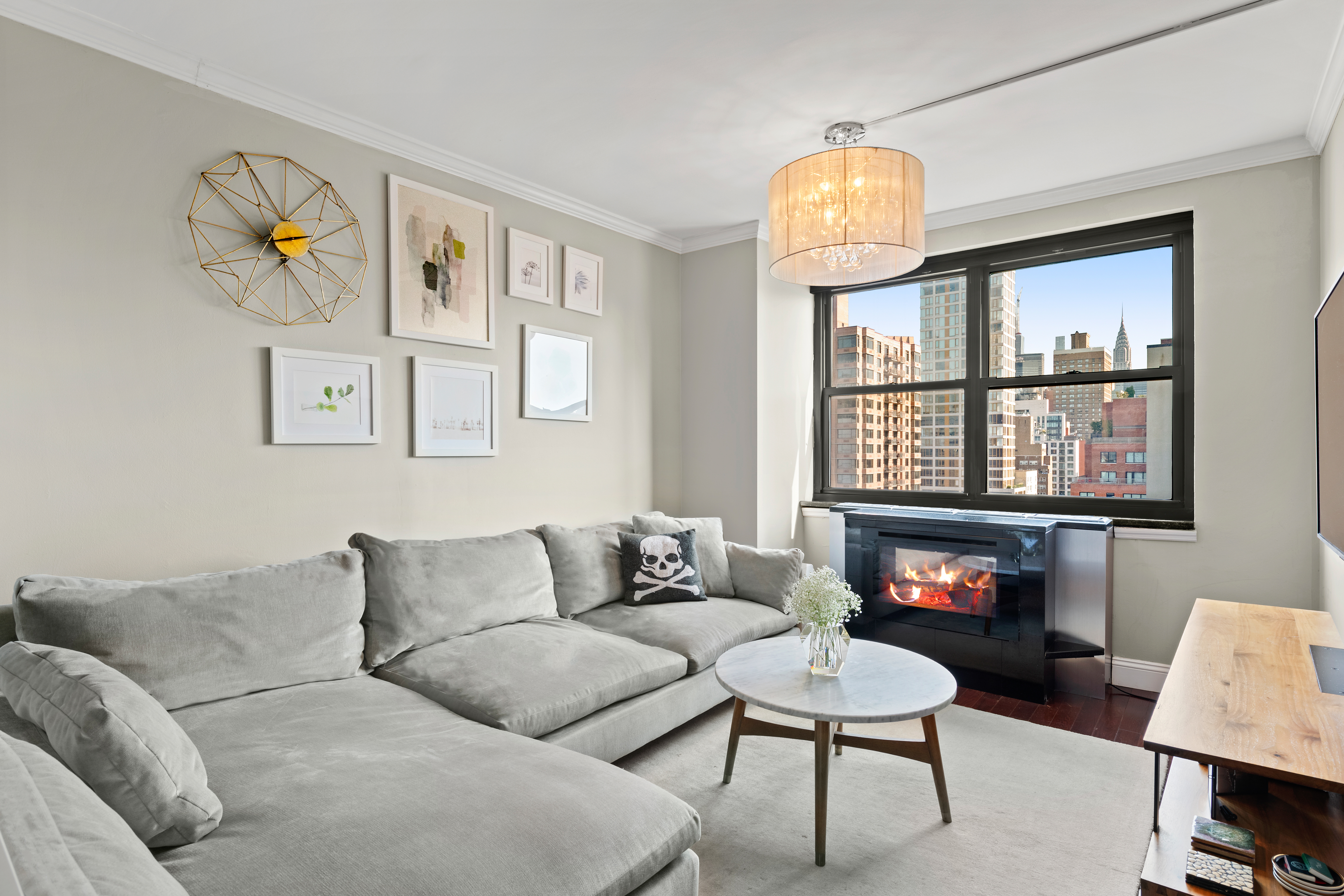 200 East 24th Street, Unit 1807 Manhattan, NY 10010 - Photo 2 of 10 a living room with furniture a fireplace and a window