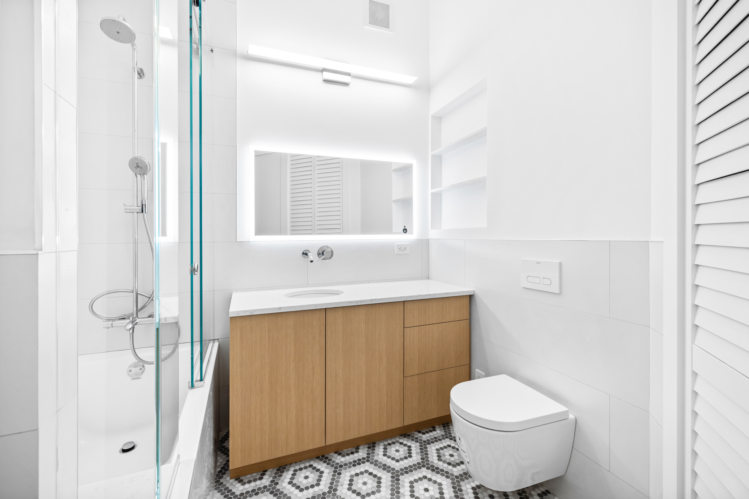 395 Broadway, Unit 5B Manhattan, NY 10013 - Photo 7 of 10 a bathroom with a sink toilet and shower