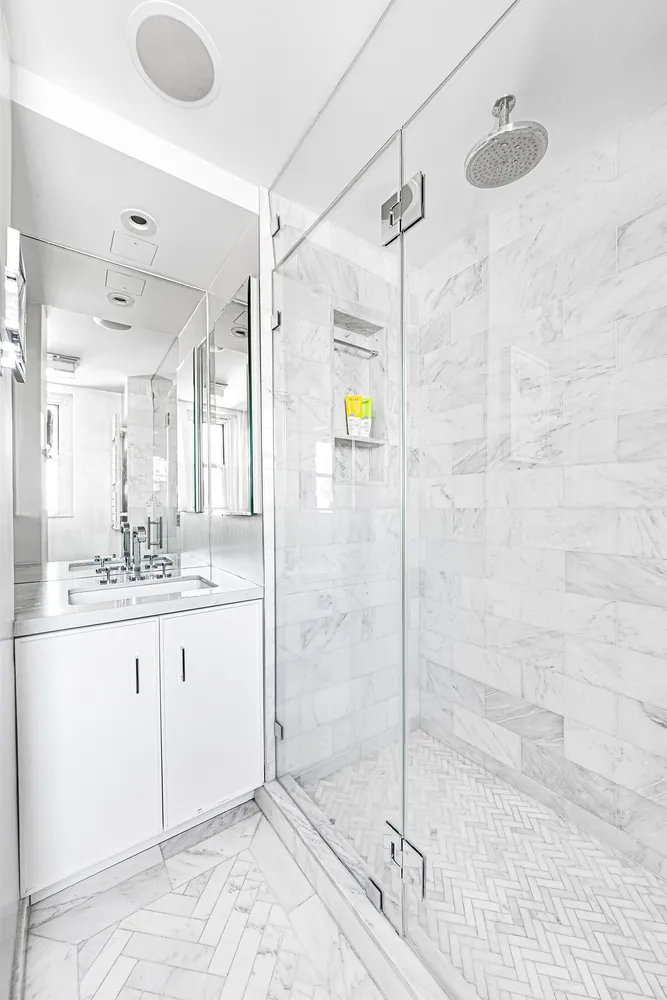 a bathroom with a granite countertop sink a mirror and shower