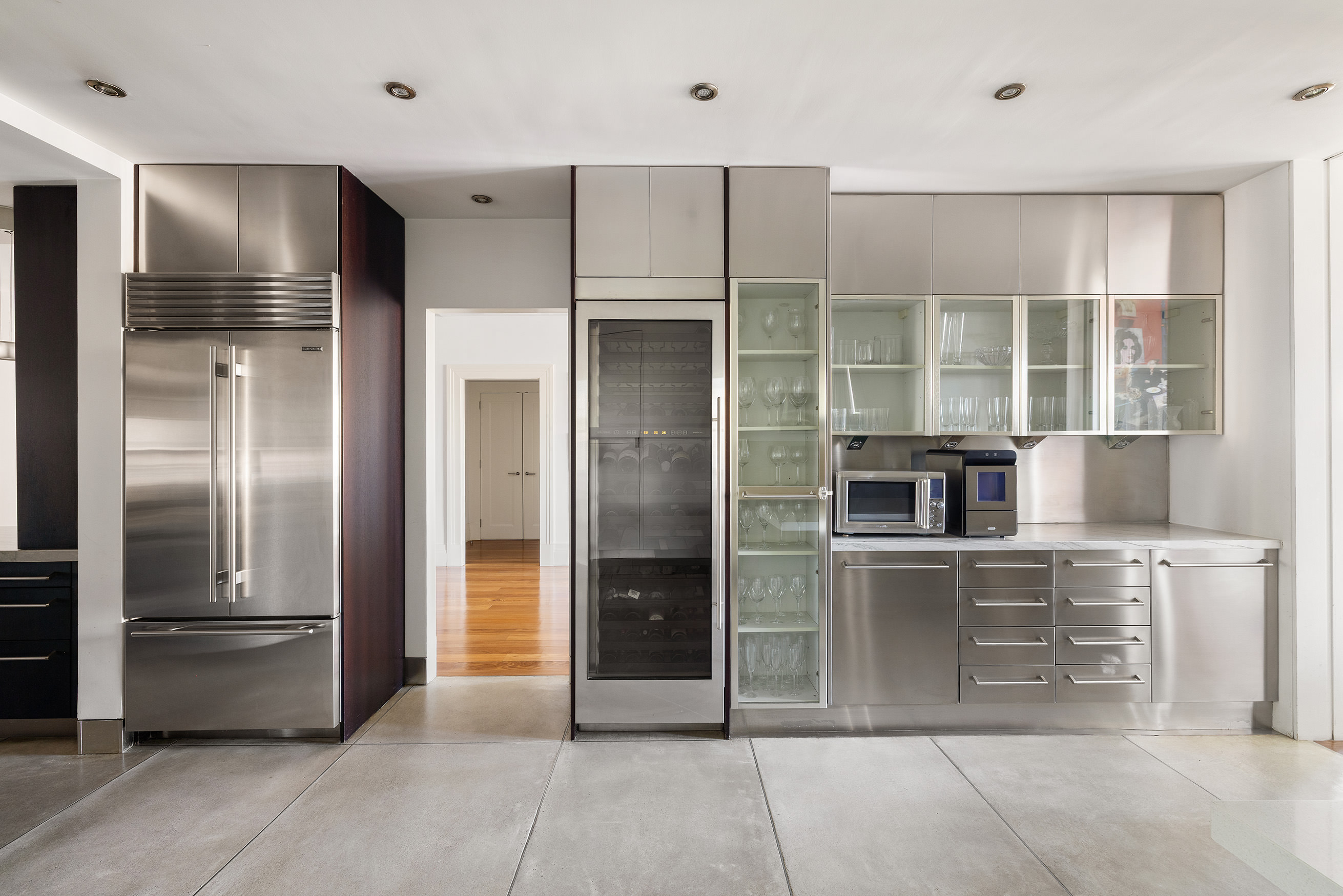 27 North Moore Street, Unit 10D Manhattan, NY 10013 - Photo 10 of 30 a kitchen with stainless steel appliances kitchen island granite countertop a refrigerator and a sink