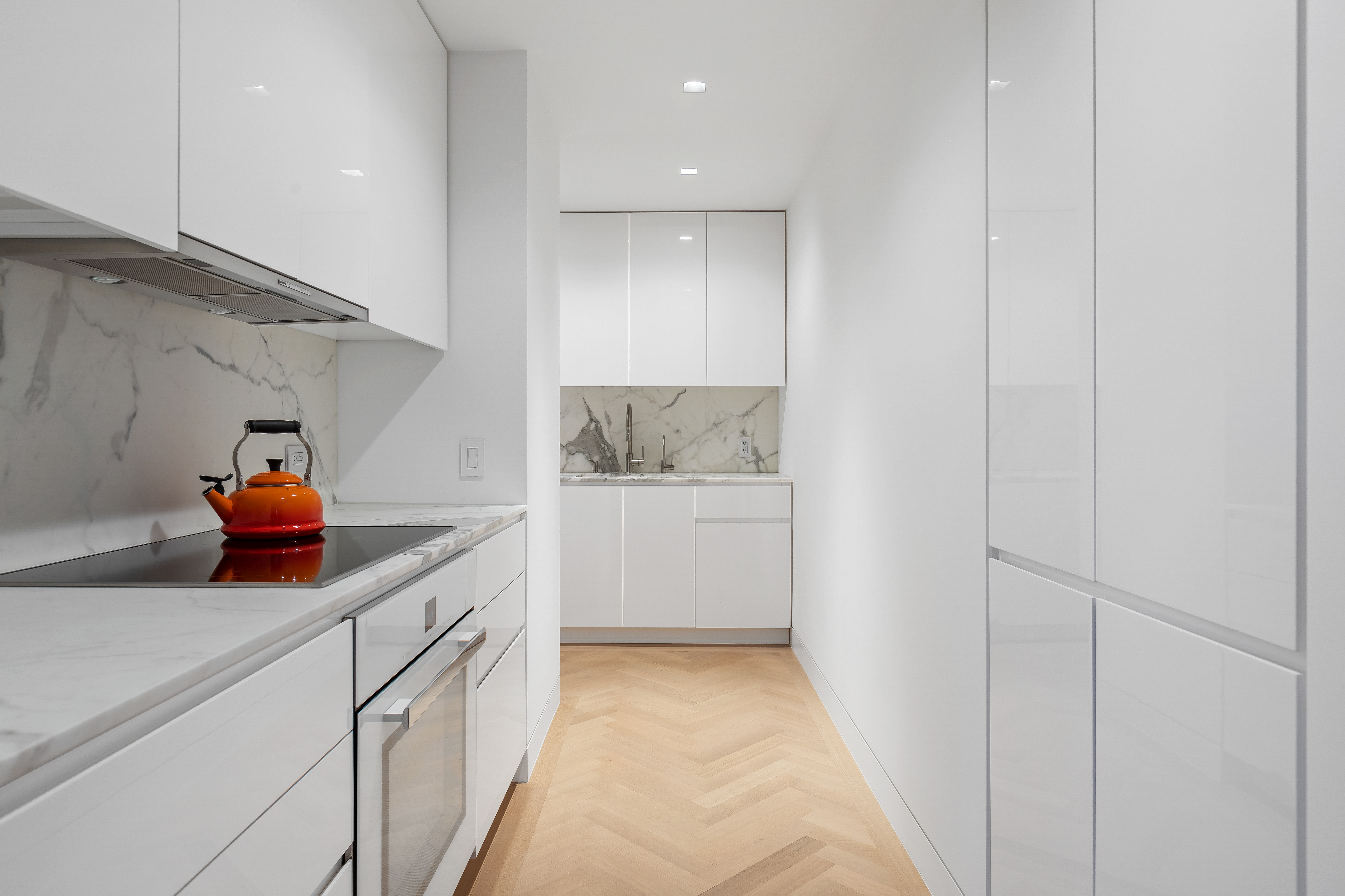 1 5th Avenue, Unit 16F Manhattan, NY 10003 - Photo 13 of 23 a kitchen with white cabinets and white appliances