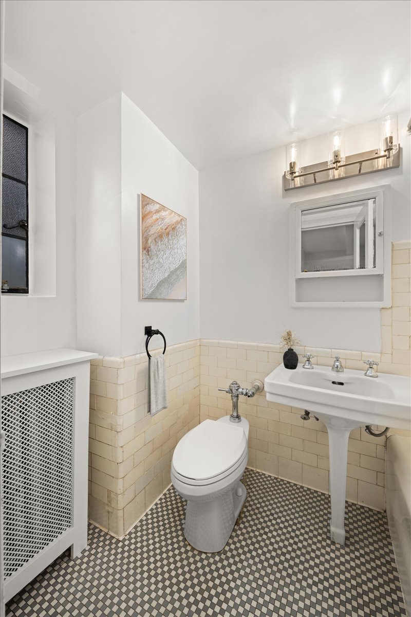 325 East 41st Street, Unit 605 Manhattan, NY 10017 - Photo 5 of 7 a bathroom with a toilet a sink and mirror