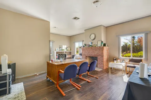 a living room with fireplace furniture and a large window