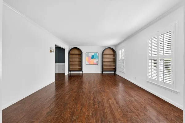 a view of a room with wooden floor and windows