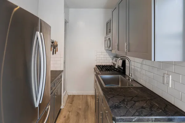 a kitchen with granite countertop a refrigerator and a sink