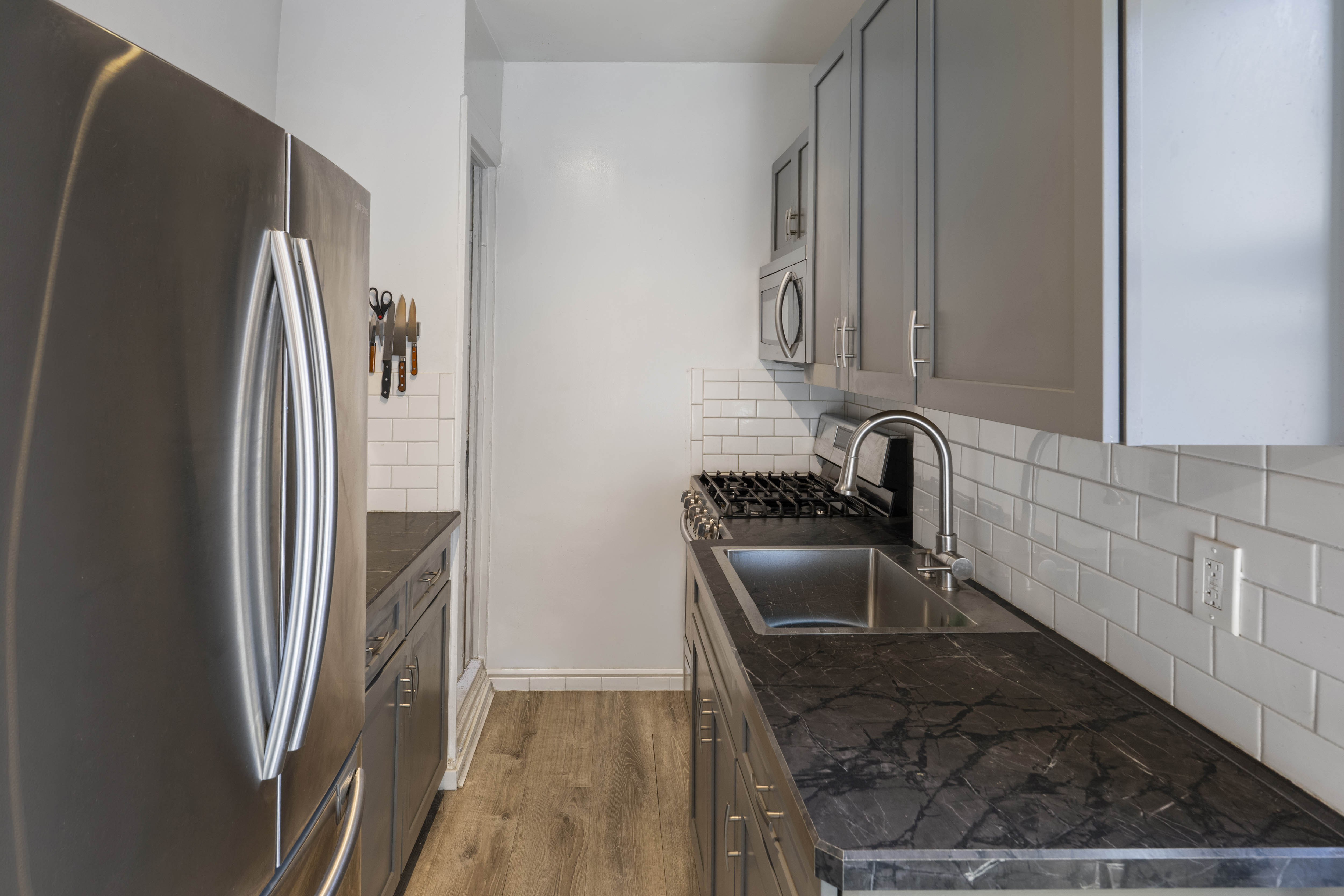 2199 Holland Avenue, Unit 5P Bronx, NY 10462 - Photo 6 of 11 a kitchen with granite countertop a refrigerator and a sink
