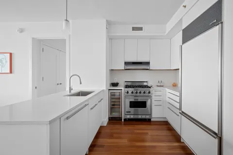 a kitchen with white cabinets stainless steel appliances and sink